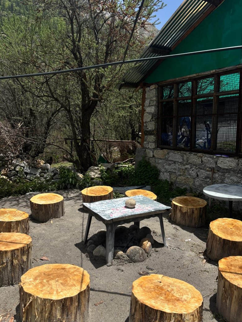 Outdoor log stump seating area next to the stone restaurant building